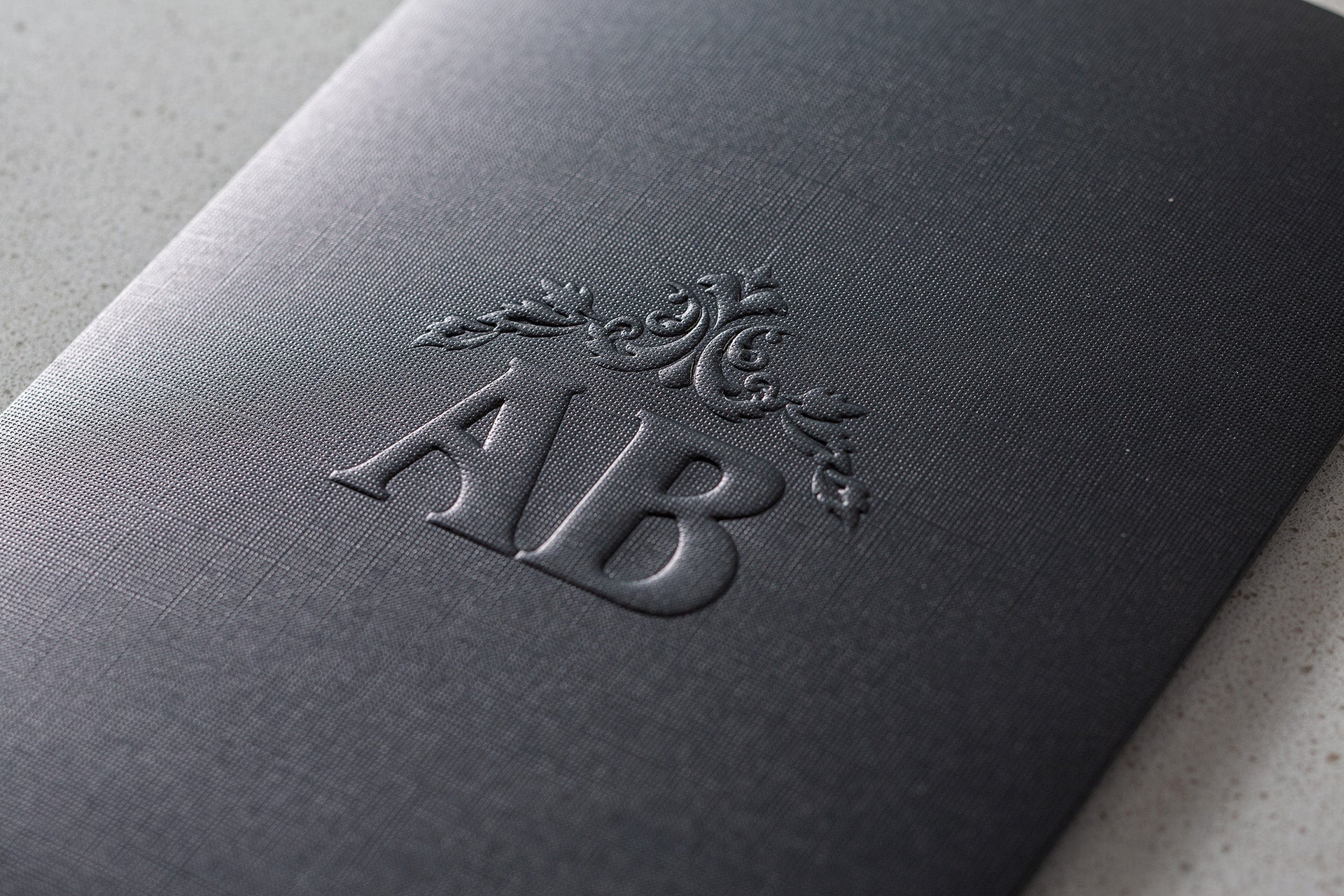İklim Davetiye 10693 - Rölyef baskı monogram ve rozet motif detayı, antrasit gri kabartmalı davetiye kapağı